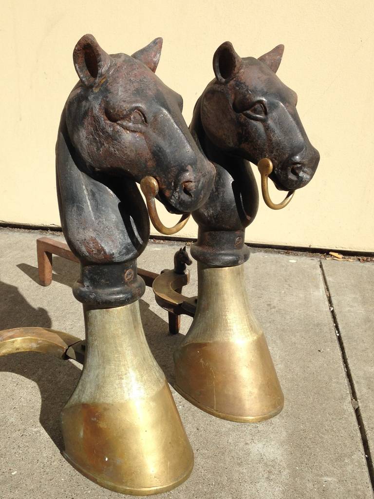 An incredibly rare pair of solid brass and cast iron antique equestrian themed andirons. The bits, hooves and smaller horses in the back are all made of solid brass. The horses atop the hooves are cast iron. A must-have for the equestrian enthusiast.