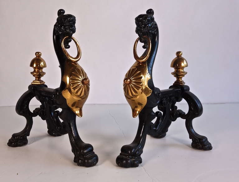 These stately andirons possess a gorgeous mix of cast iron and brass. Unusual and chock full of interesting details.