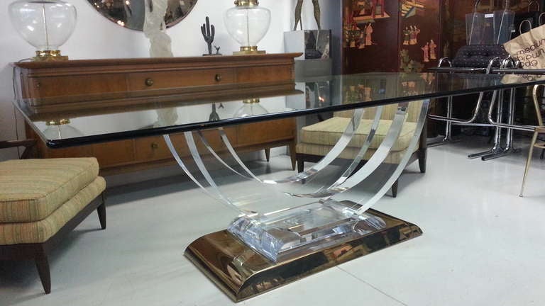 A most beautiful lucite and brass fitted dining table attributed to Karl Springer.
the design andcombination of materials on this piece is just fantastic.
the lucite a different angles has prism like effect.
base is of solid brass and compliments