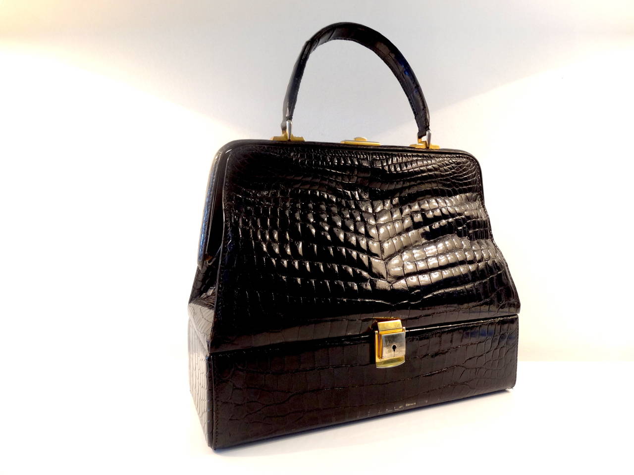 An unusual handbag by Lederer. Bag is finished in a high gloss black crock.
The design of this handbag is most unusual with a hinged base. 
Simple elegant bag.
Height with handle up 15