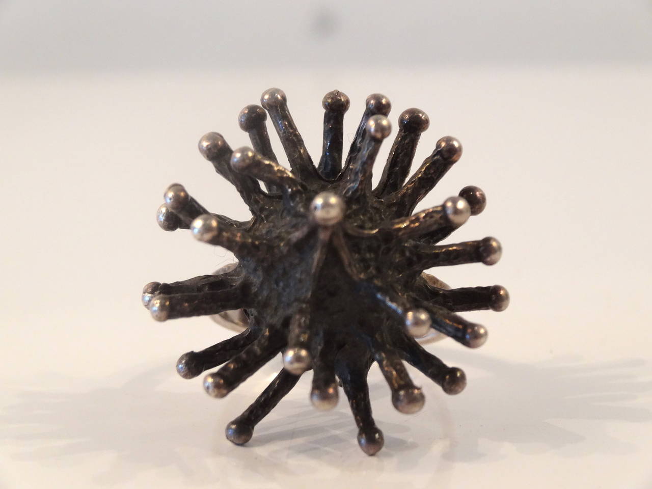 A Brutalist style ring in the form of a sea urchin. This ring is stamped 925 and from the 1960s.
Ring size is approximately 8.