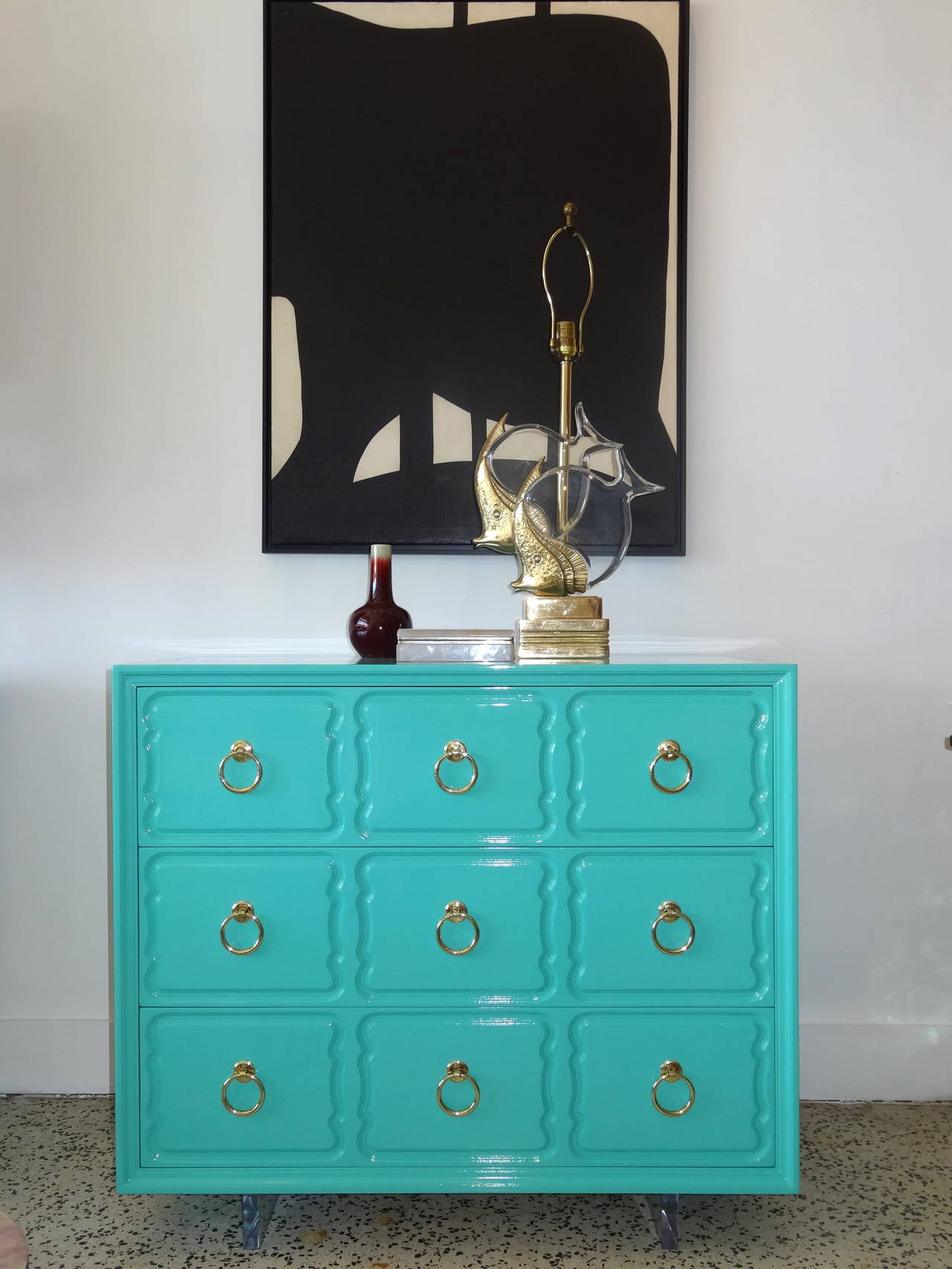 An updated and modernized Dorohty Draper commode.
This piece has been updated with a fresh new lacquer finish, polished original hardware and floating on lucite rails as its base.
This piece maintains the original interior paint and color.