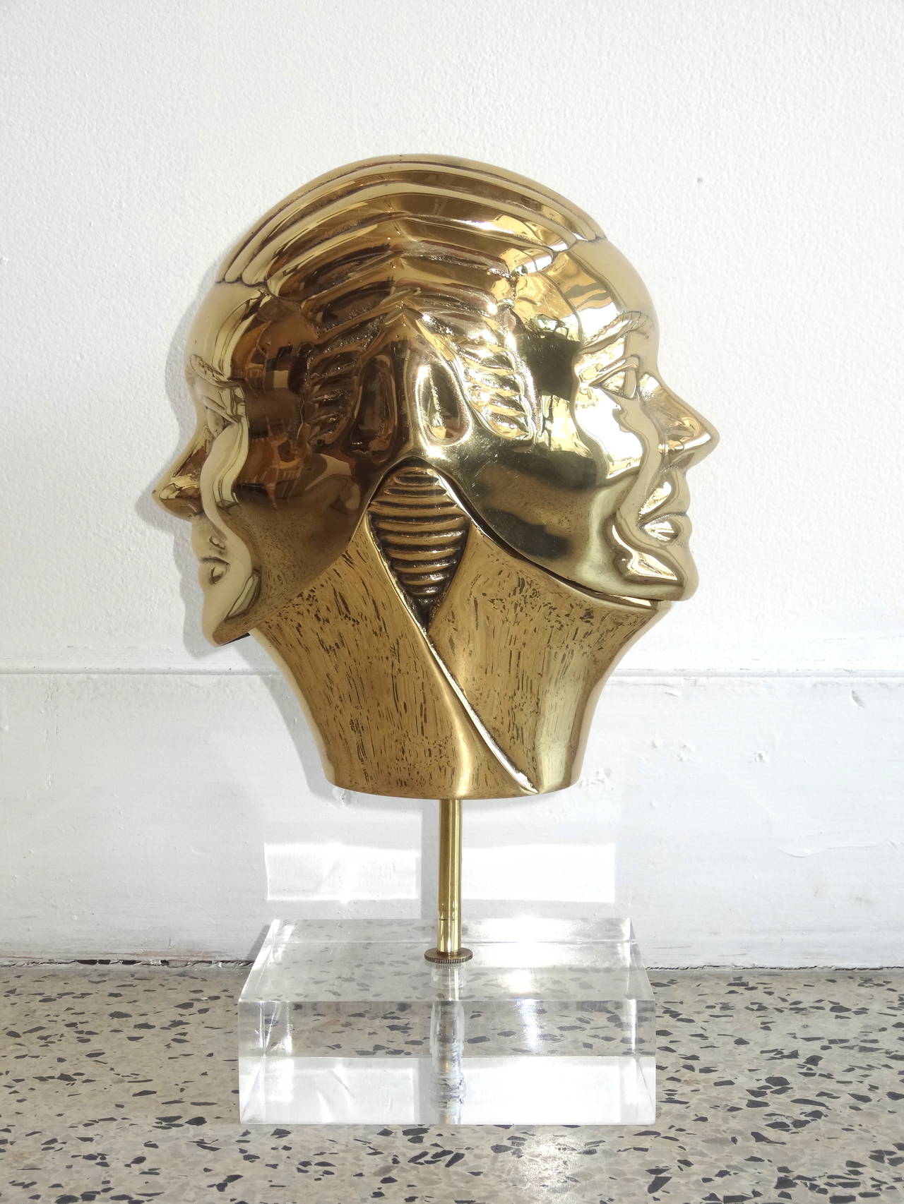 Lidded brass sculpture in a shape of two faced head on Lucite pedestal. Brass is just polished with clear lacquer over polished finish.
Most interesting design with the mirror image faces and removable 