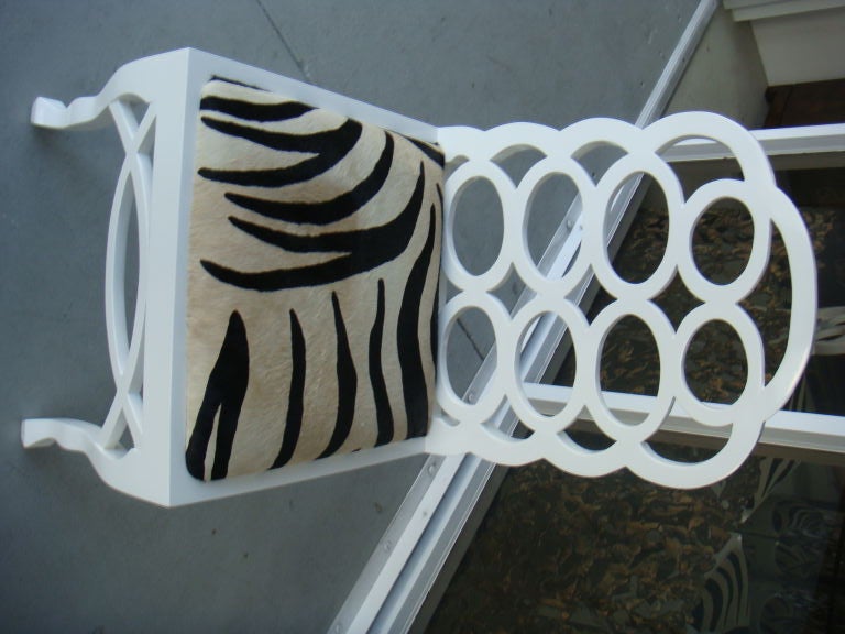 A set of 4 Francis Elkin chairs which have been redone and updated with a fresh coat of lacquer and cowhide upholstery which looks like zebra. The combination of the circles and the upholstery make this set totally glamorous .
