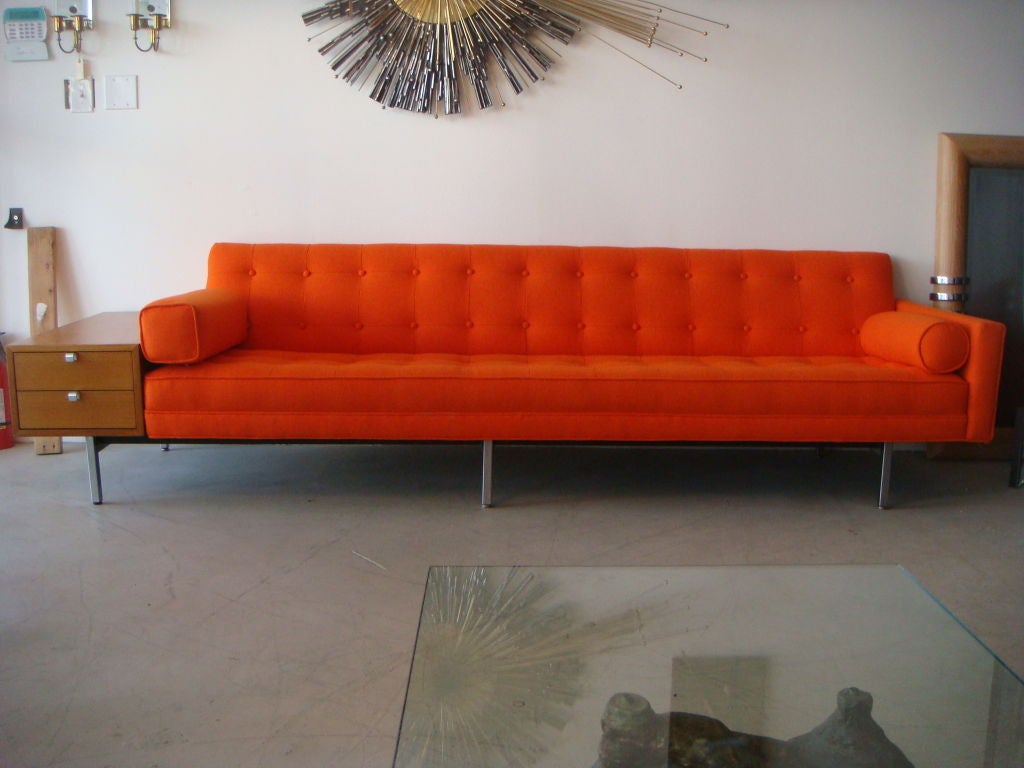 AAn iconic example of midcentury design. Designed by George Nelson for Herman Miller circa 1953.This piece with the attached end table is hard to find and quite rare. It has been beautifully reupholstered in a vintage Knoll style fabric. This piece