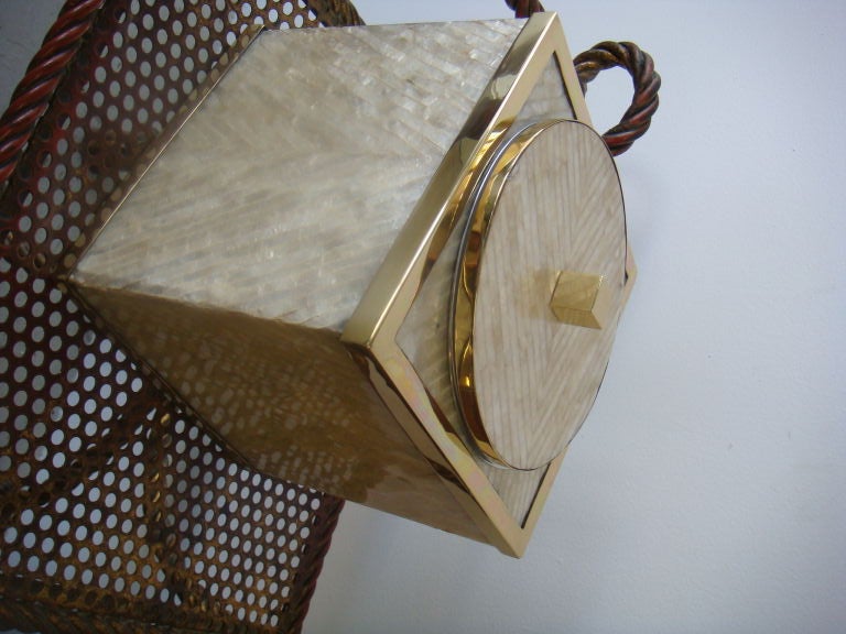 An ice bucket of capiz shell and brass trim. A modern design with glamorous finishes.Styled and from the Karl Springer Era. Ice tongs included!