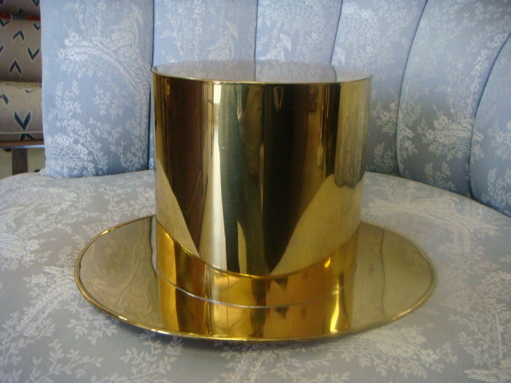 A brass ice bucket in the form of a top hat. Great shape and size. Classically <br />
Styled and a fun way to serve your champagne