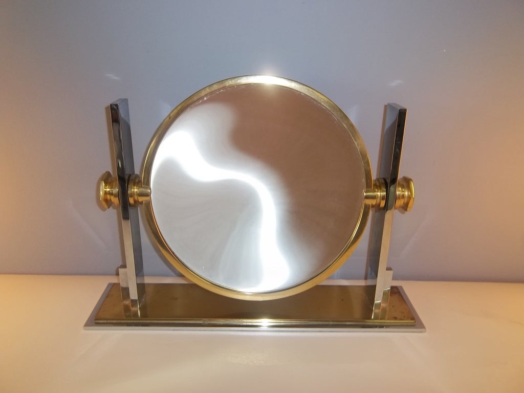 A vanity mirror of chrome and brass by Karl Springer
