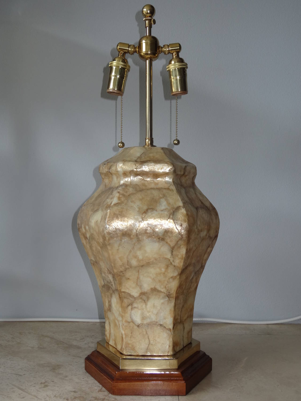 Beautiful pair of Capiz shell covered urn lamps with wood and brass pedestal great scale and form. Lamps have been rewired and brass polished.