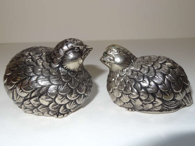 A pair of silver colored salt and pepper shakers in the form of a qual. Beautiful details
