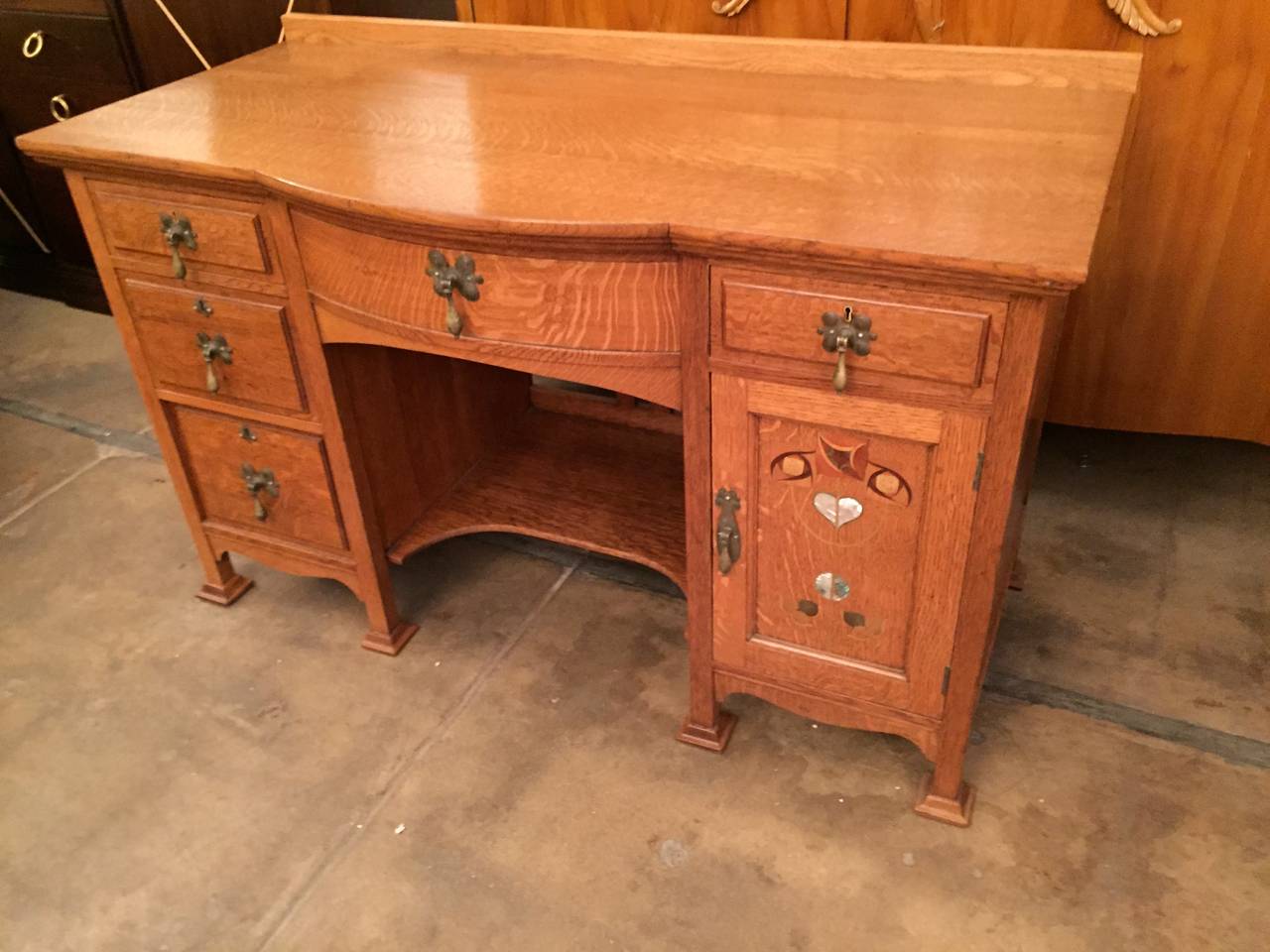 A wonderful small desk or cabinet in golden oak with mother-of-pearl inlays and brass tear drop pulls by the Famed Arts and Crafts company, Shapland and Petter. Maker's mark.