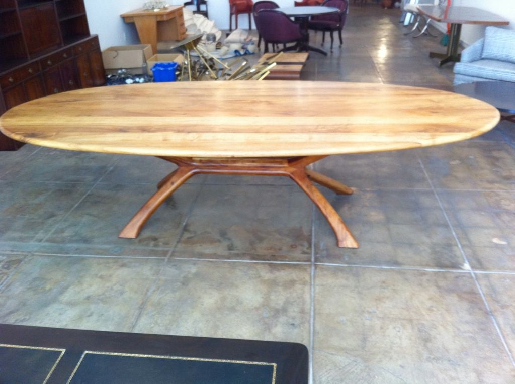 A beautiful large 9.5 foot California craftsman Koa wood table from the mid-70s by noted craftsman, Griffin Okie. An oval/race track top on a whale/wish bone shaped base.Came out of a home in Carmel ,CA .Rare