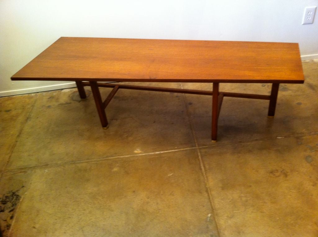 A rare 1950's walnut architectural style coffee or low console table with brass sabots by Edward Wormley for Dunbar.