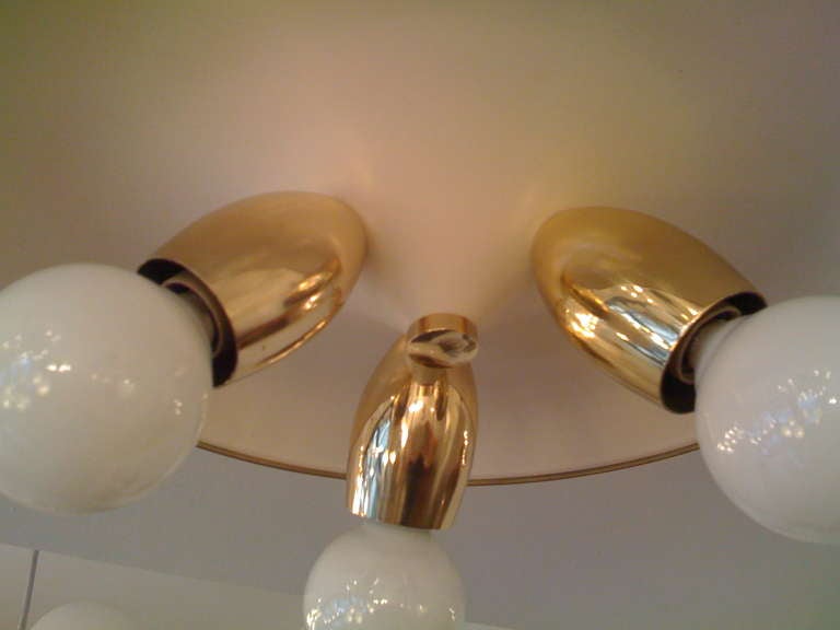 A 1950s Italian three light polished brass and white enamel flush light by the firm Arteluce.