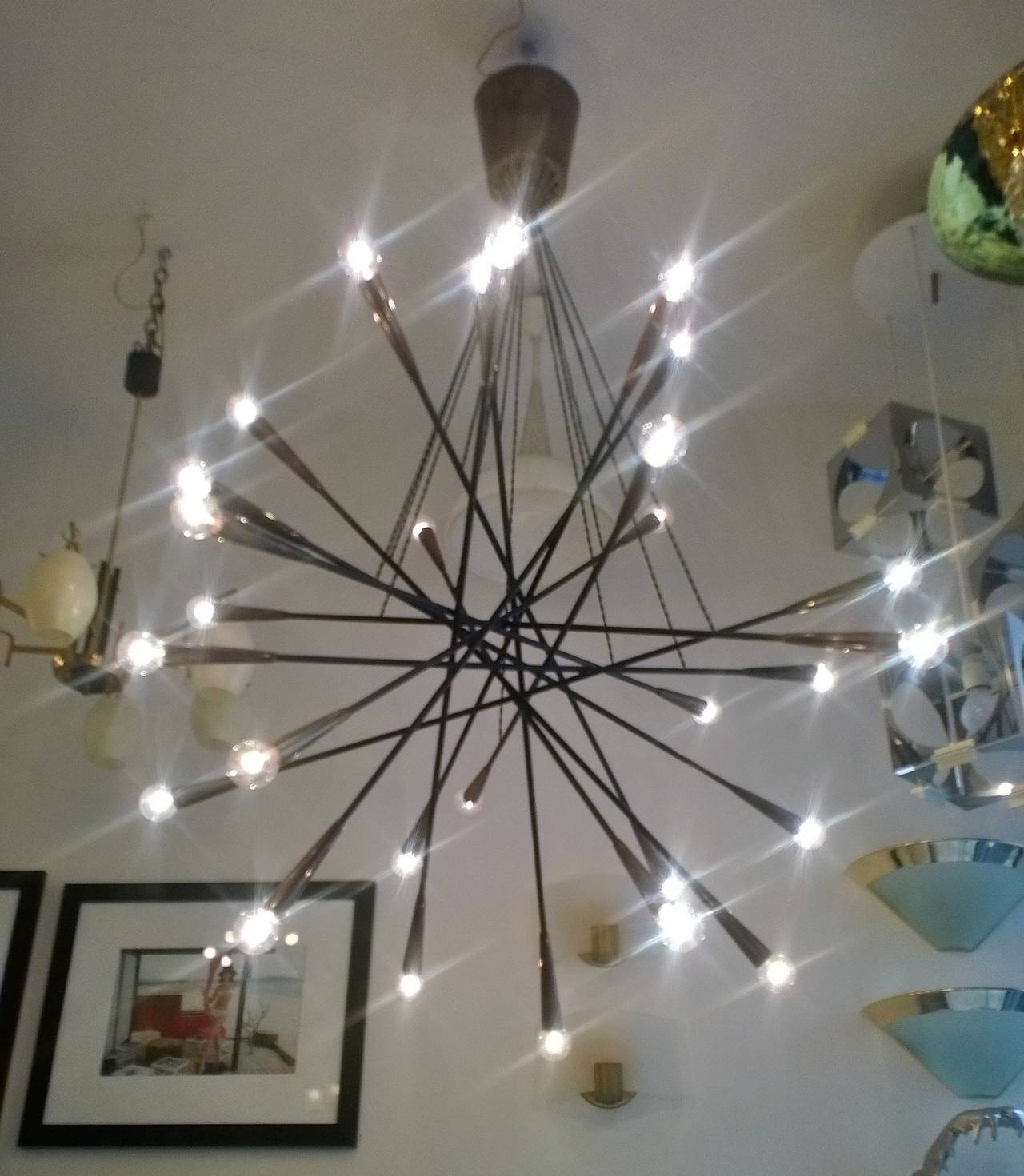 An original 1950s large Italian 26 light chandelier. It is composed of aged brass rods and cone sockets suspended by twisted silk electrical cords.
