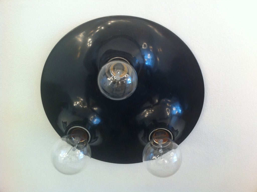 An iconic black PVC flush ceiling light by Italian designer, Vico Magistretti for Artemide.