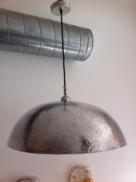 Una grande plafoniera a mezza cupola martellata con accessori e baldacchino coordinati.
