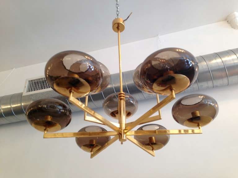 An Italian  polished brass gold tinted fixture with smoked glass shades. Nine light sources.