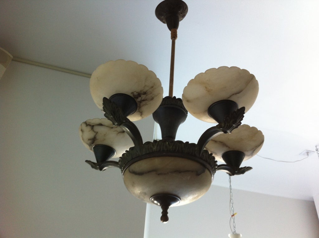 A four light decorative bronze fixture with scalloped alabaster shades.