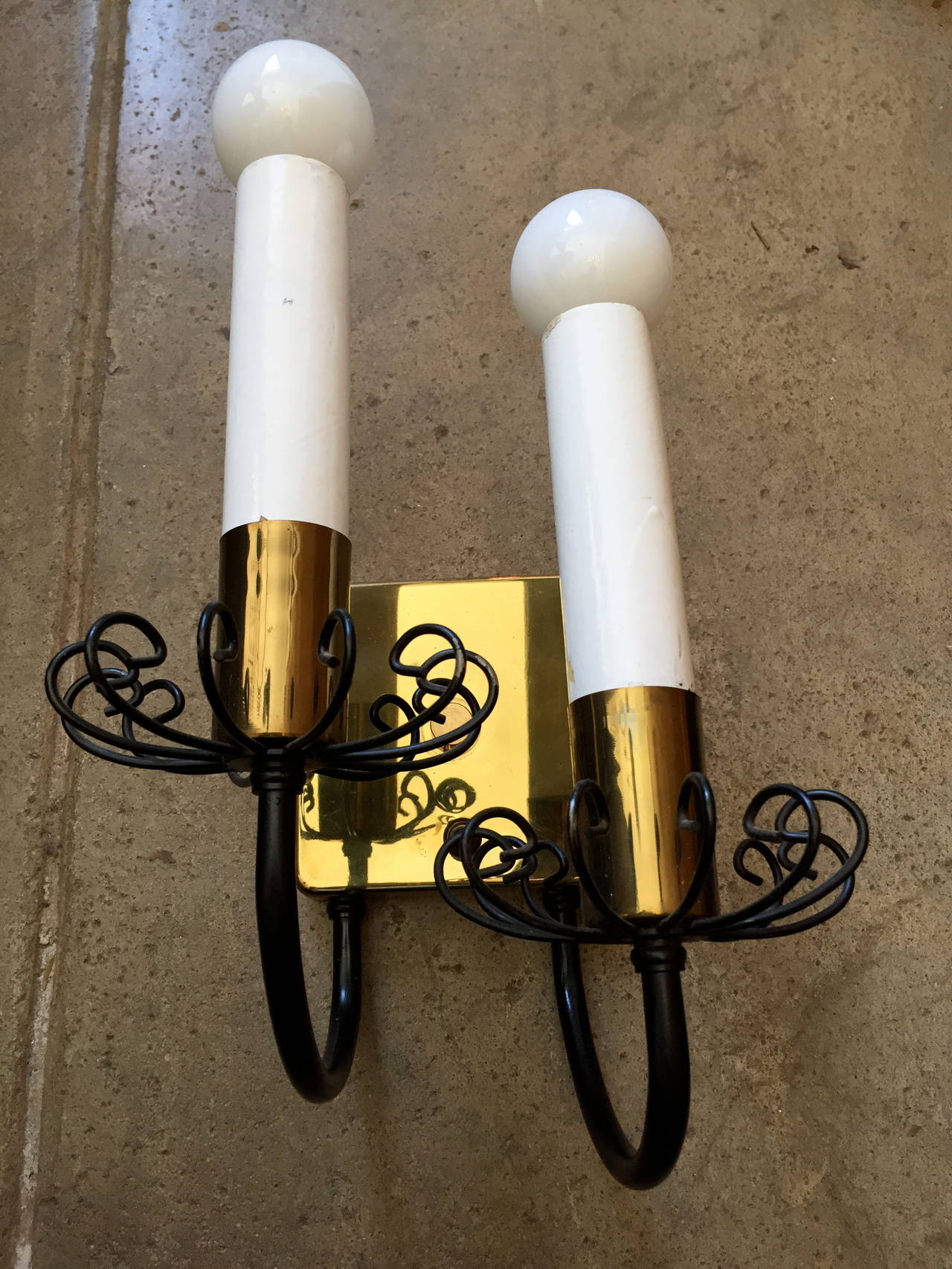 An original pair of 1960s polished brass and black enamel Regency style American wall lights. Rewired.