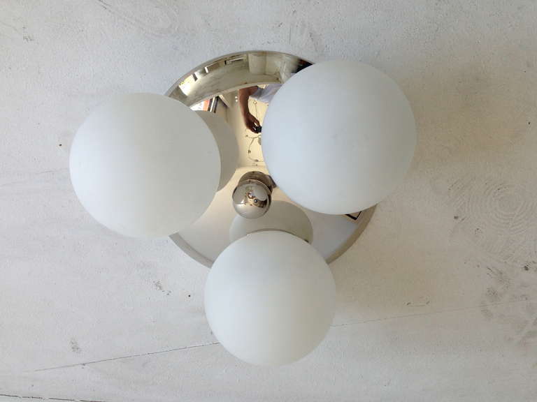 A sleek 1960s Italian chrome flush ceiling dick light with three frosted globe shades. Rewired