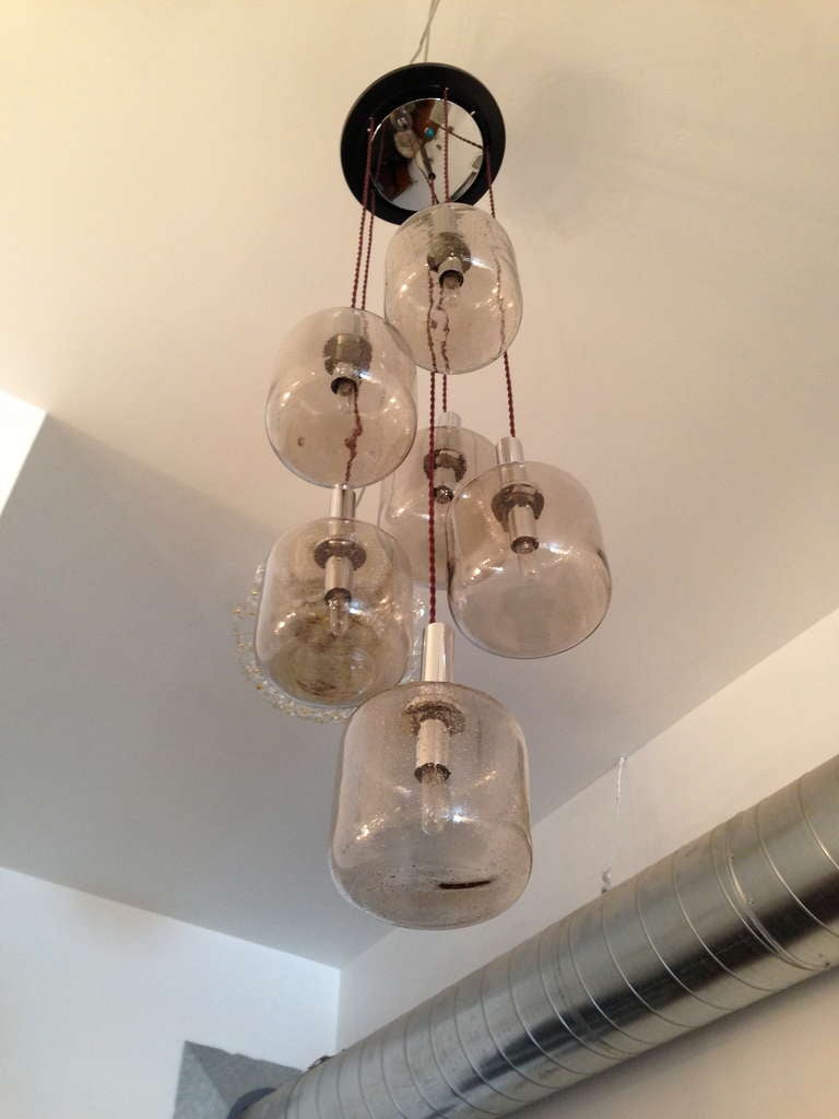 A 1960s Italian six-light cascading chandelier with clear bubbled blown glass shades on a chrome and black enamel fixture with rayon cords. Rewired.