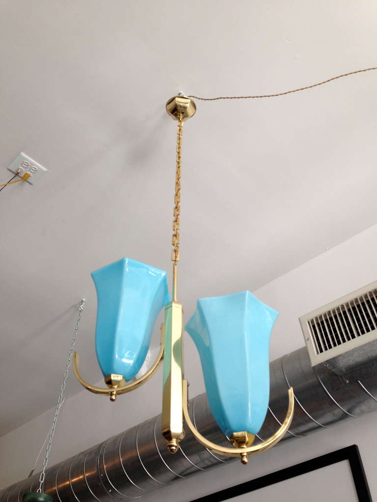 A rare 1920 Austrian Secessionist chandelier composed of a polished brass fixture with blue opaline glass shades. The fixture has decorative prism shaped elements, silk cord and square link chain. Rewired. We can adjust the chain as needed.