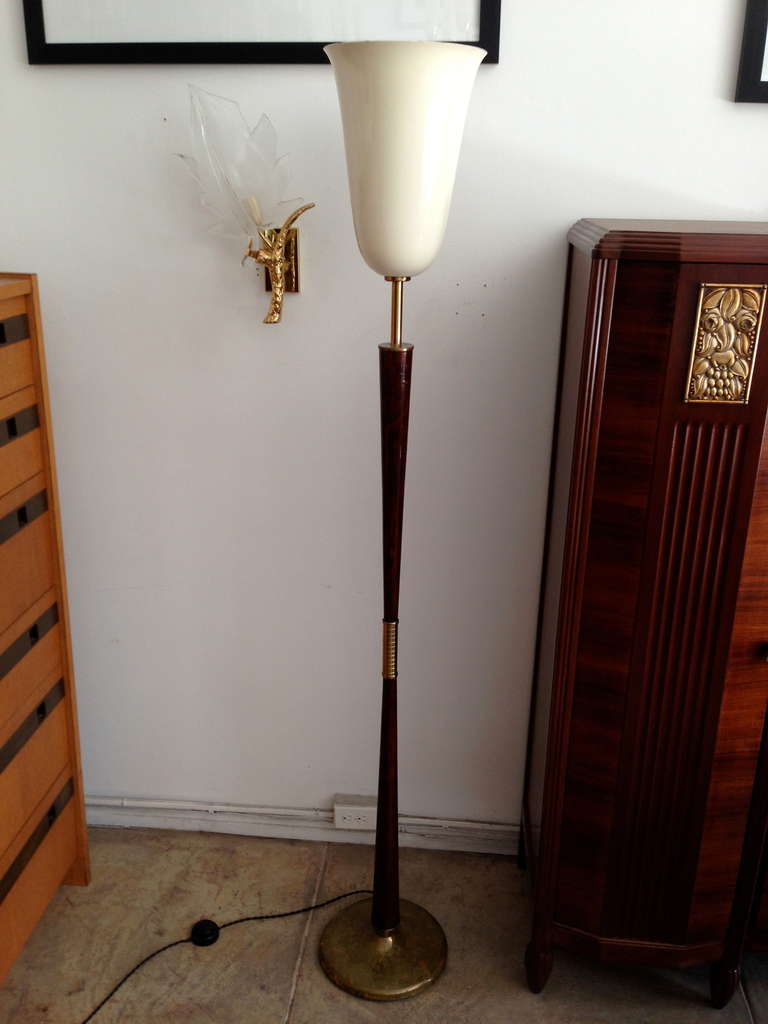 An elegant 1920s Italian Art Deco torchiere floor lamp done with a walnut body and aged brass decorative elements and base with cream enameled shade. Rewired with a silk cord and foot switch.