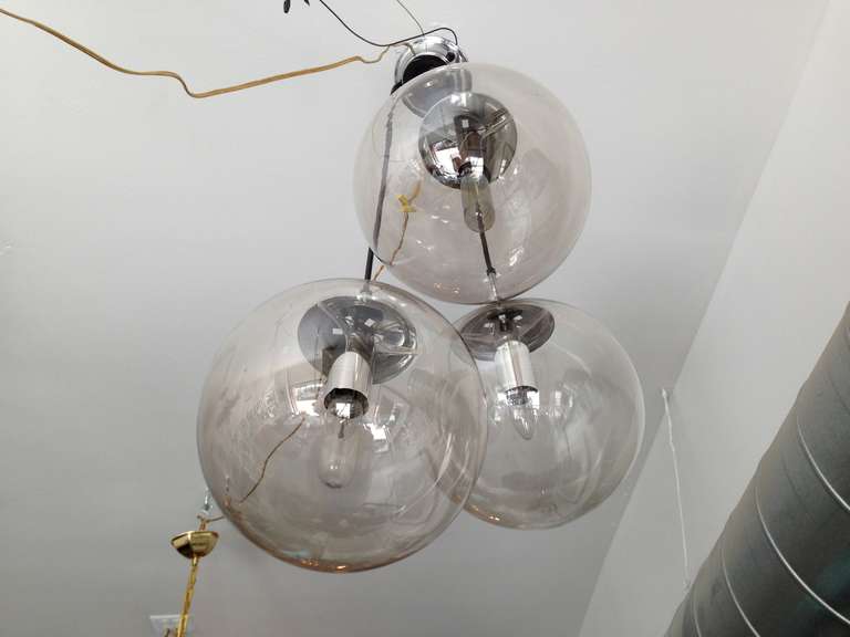 A sleek pair of German 1970s flush or hanging pendants composed or three large blown glass balls on a chrome fixture made by the famed lighting and glass company, Limburg. Original label. Rewired. Cords can be shortened or lengthened.