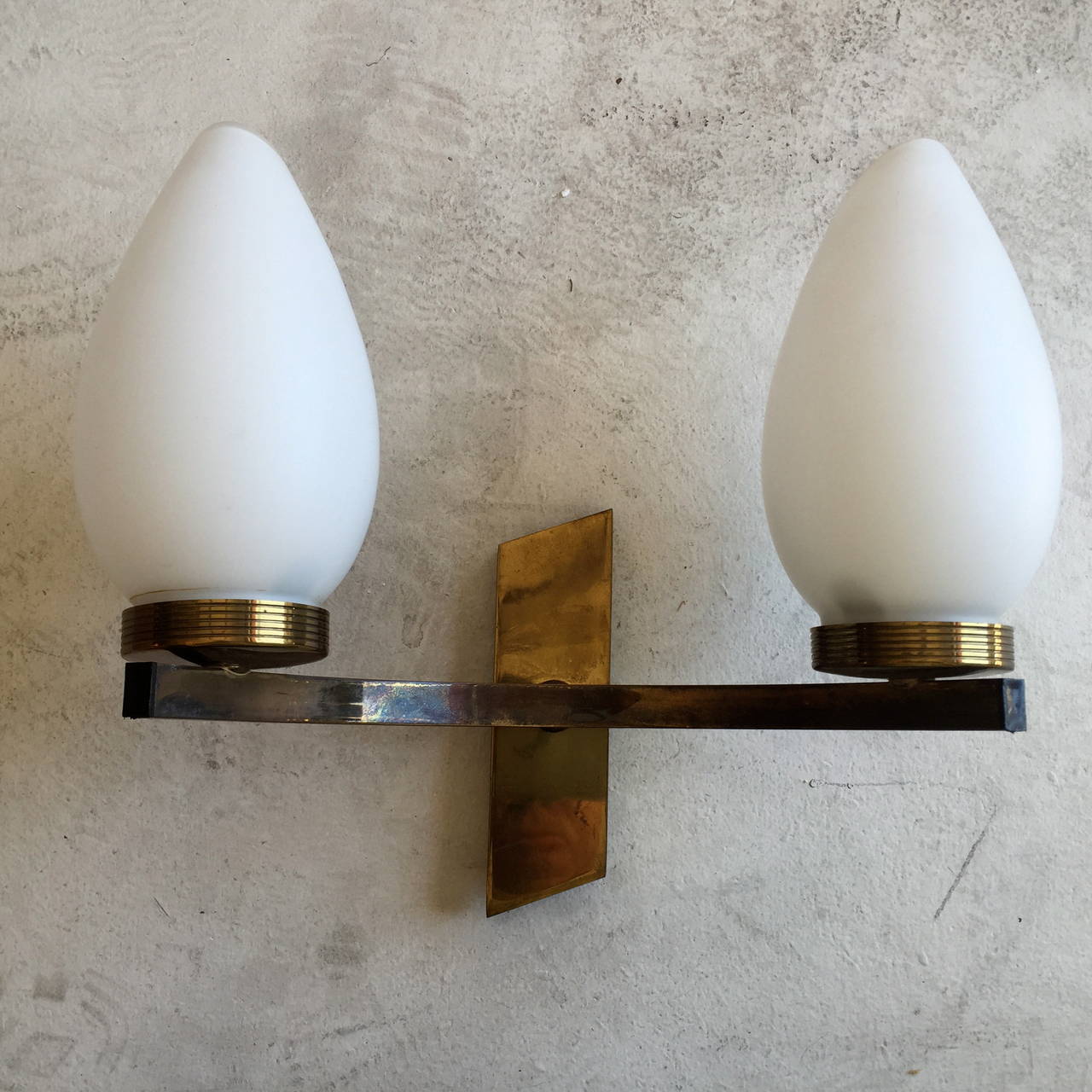 A great pair of 1950s French wall lights with aged brass fixtures and frosted tulip glass shades. Rewired.