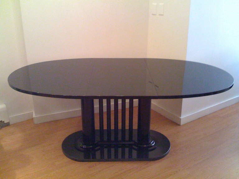 A 1983 high glass black lacquer Bauhaus style  oval dining table with a black granite base designed by the famed architect, Bruno Paul. One leaf. 75 inches, with leaf.