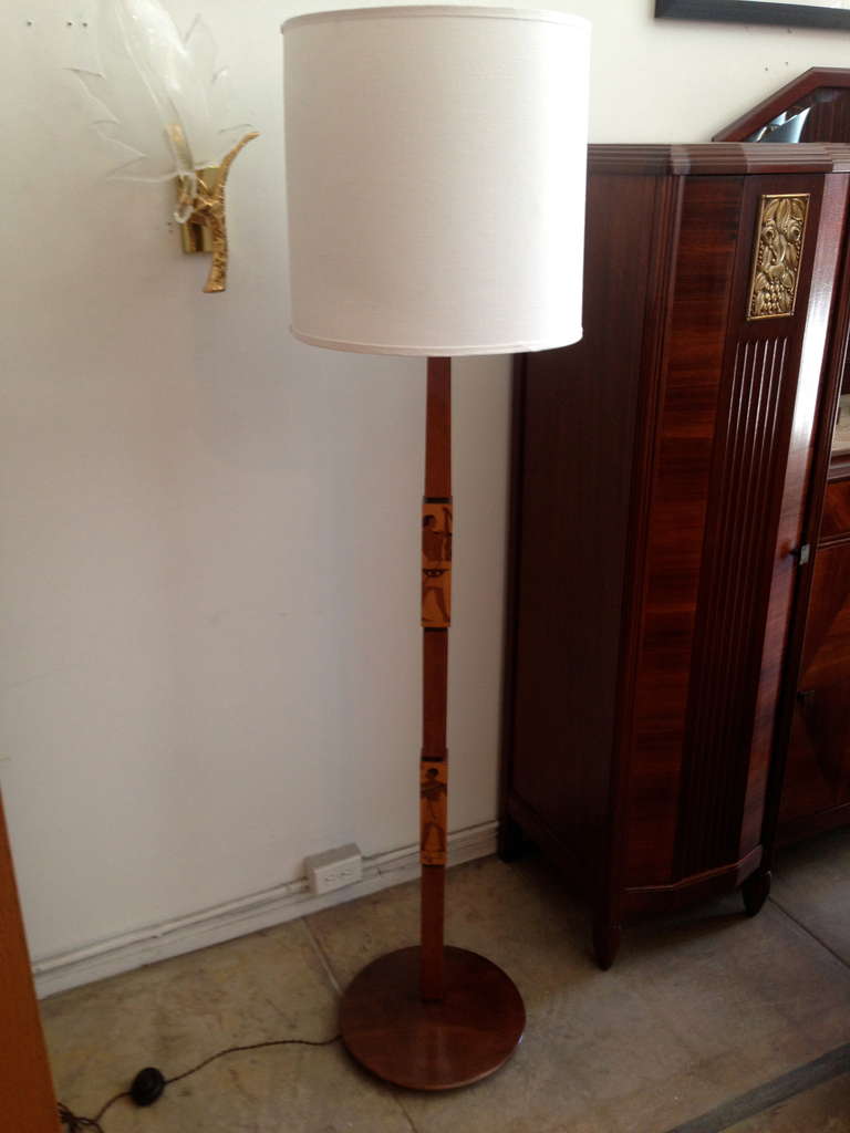 A fantastic rare 1920s Italian Art Deco inlaid wood and bronze floor lamp. The lamp is composed of a mixture of woods with inlaid parquetry Egyptian figures. Rewired with a silk cord and foot switch. The lamp has an uplight and three Directional