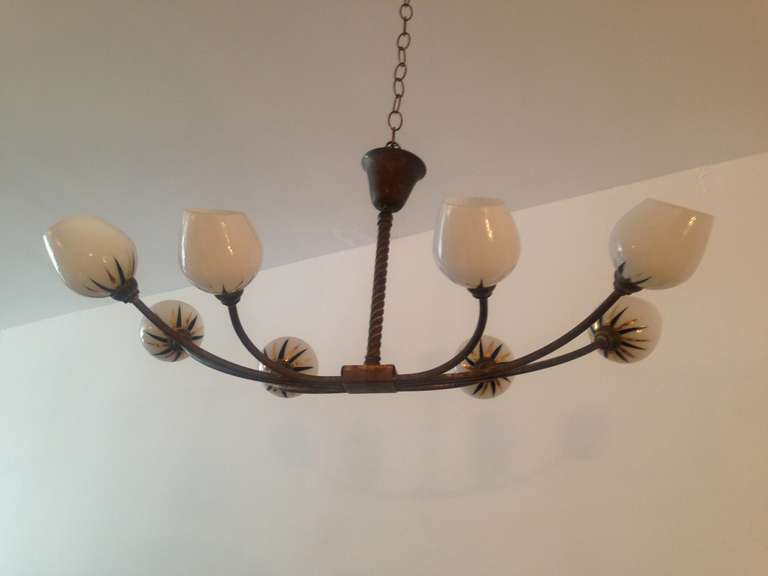 A nice 1940s French eight-light chandelier composed of a bronze fixture with decorative enameled opaline glass shades.