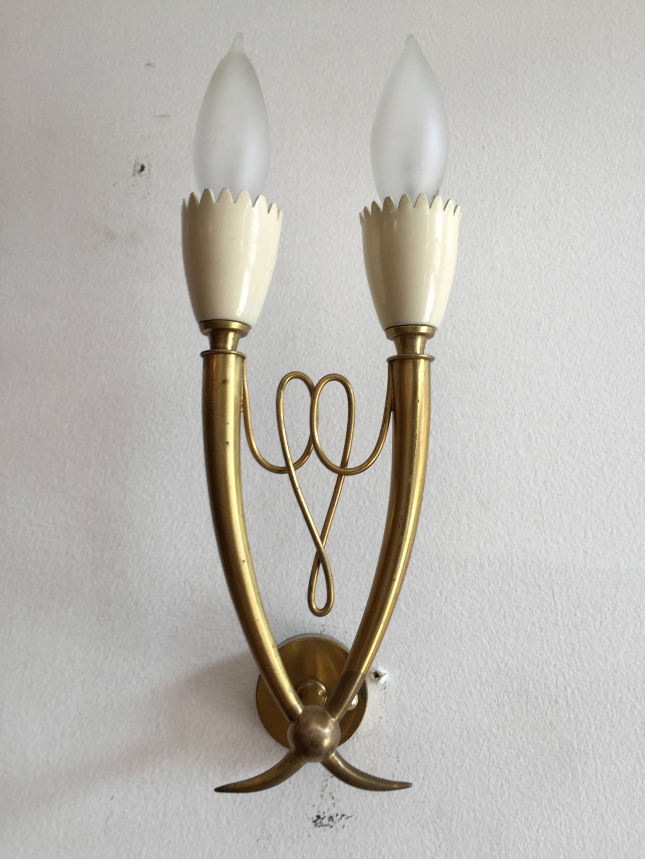 A pair of 1960s Italian Mid-Century sconces done in aged polished brass with white enamel holders. Rewired. A circular polished brass disc to cover the electrical box is provided.