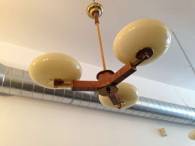 A 1920s Austrian pecan wood and brass fixture with 3 custard glass shades.