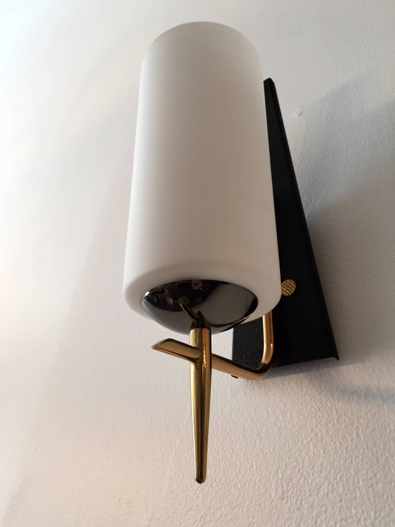 A nice sleep pair of French 1960s modernist wall lights composed of triangular black matte backs with polished brass and gun metal holders. Rewired. Large white glass shades.