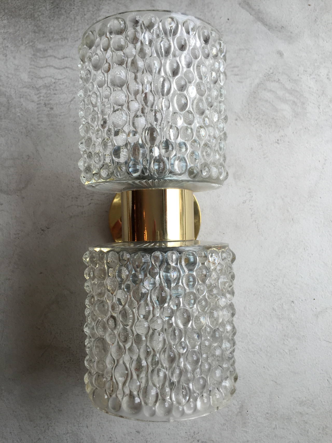 . A great luxurious polished brass wall lights with thick bubbled glass shades. The Dutch sconces were made by the lighting company, RAAK. Two light sources and rewired, original labels.three available.