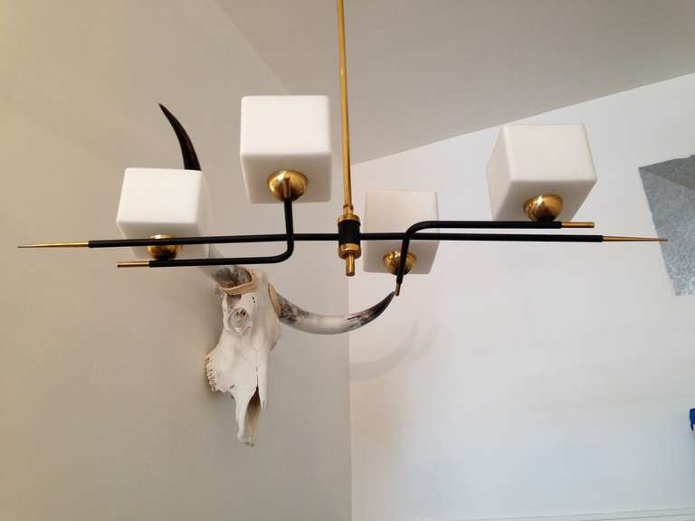 A 1960's French Space Age 4 light chandelier composed of a brass and black enamel fixture and white cube glass shades. Rewired.