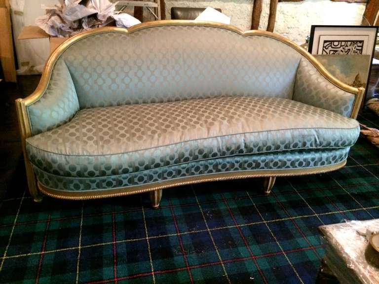 A beautiful French Art Deco sofa with a gesso applied to wood and gold leaf frame and reupholstered in a light green silk with down cushioning. These are a Fine example of French Deco with fluted front legs that have a slight arch and rest on ball