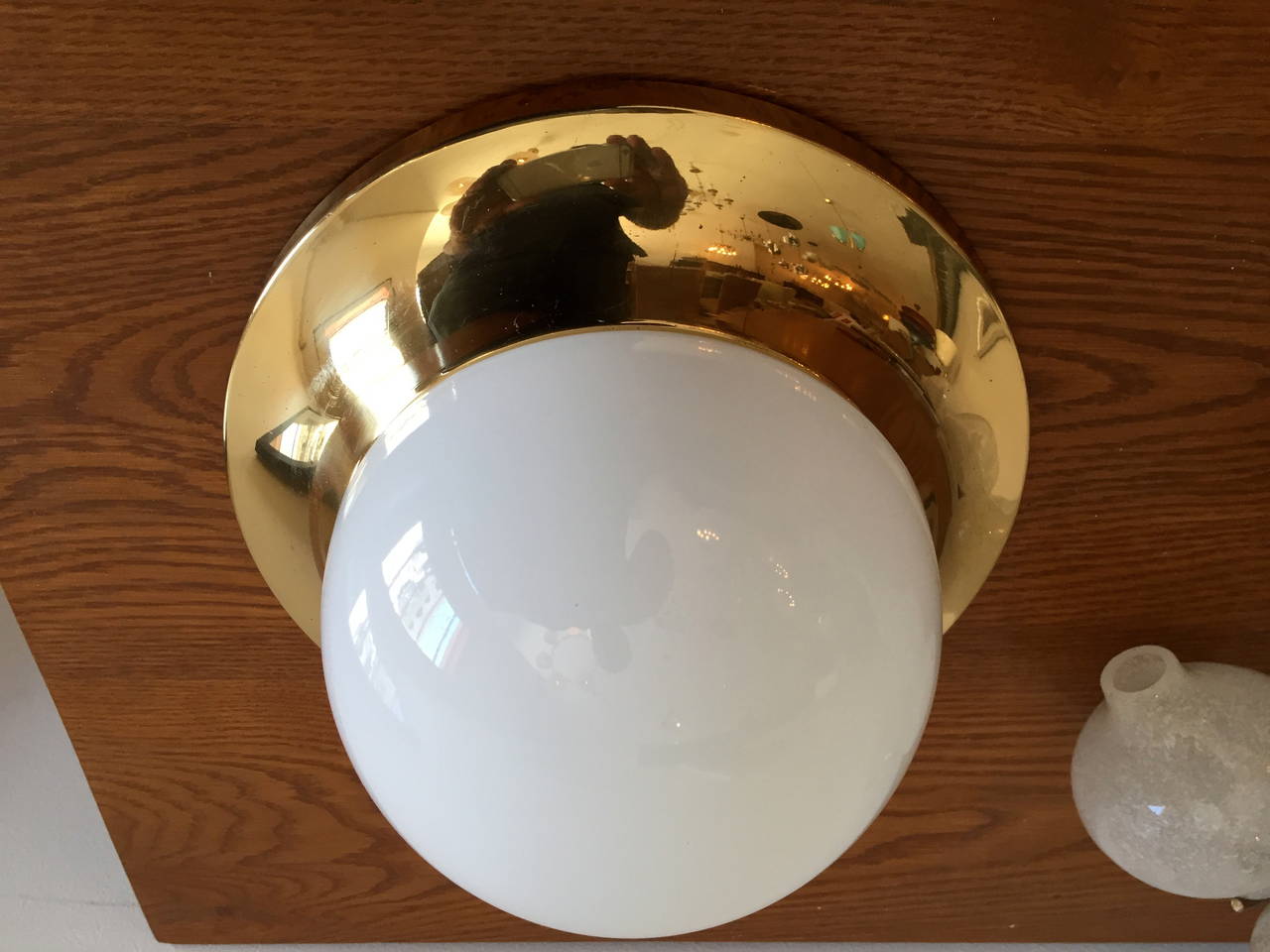 A 1960s Austrian Mid-Century flush ceiling light composed of a high polished golden brass fixture with a white opaline glass globe shade. Rewired.