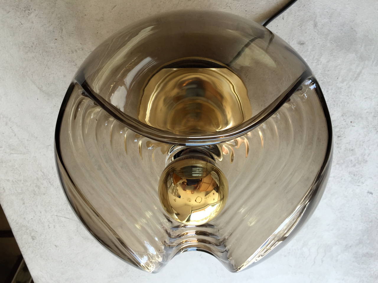 A Space Age German smoked glass ceiling or table lamp with a gold base by Peill & Putzler.