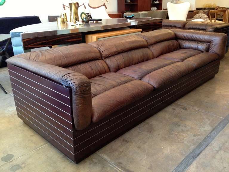 A wonderful large 1980s Italian cube sofa with natural leather seats. The rectangular cube case is a dark burgandy/brown enamel with inset steel strips. The leather is a medium worn soft chocolate brown.