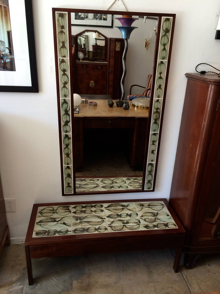 A wonderful 1950s Poul Jensen rosewood low table and mirror with inlaid L. Hjorth tiles. The low table has three drawers. Signed. The mirror is 51" H x 29.5" W x1.5" D.
