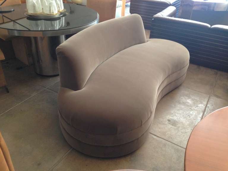 A 1930s curved back American Art DEco sofa upholstered in a Mink color antique velvet.