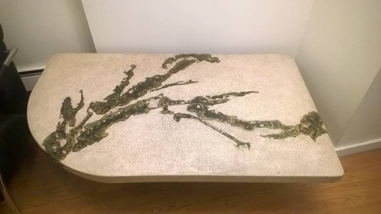 A rare 1970s sculptural coffee table by the famed American artist Silas Seandel. The table is composed of a stone composite and inset bronze resting on a bronze base. Signed.