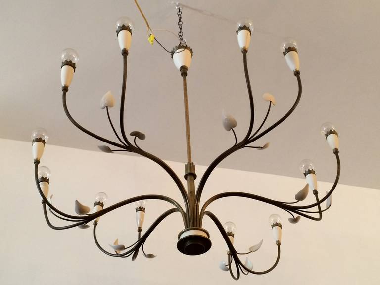 A large, elegant 1950s Italian swooping chandelier with a wonderful warm patina and cream enamel decorative leaves. 12 light sources. Rewired. The stem can be lengthened. Strada Milano.