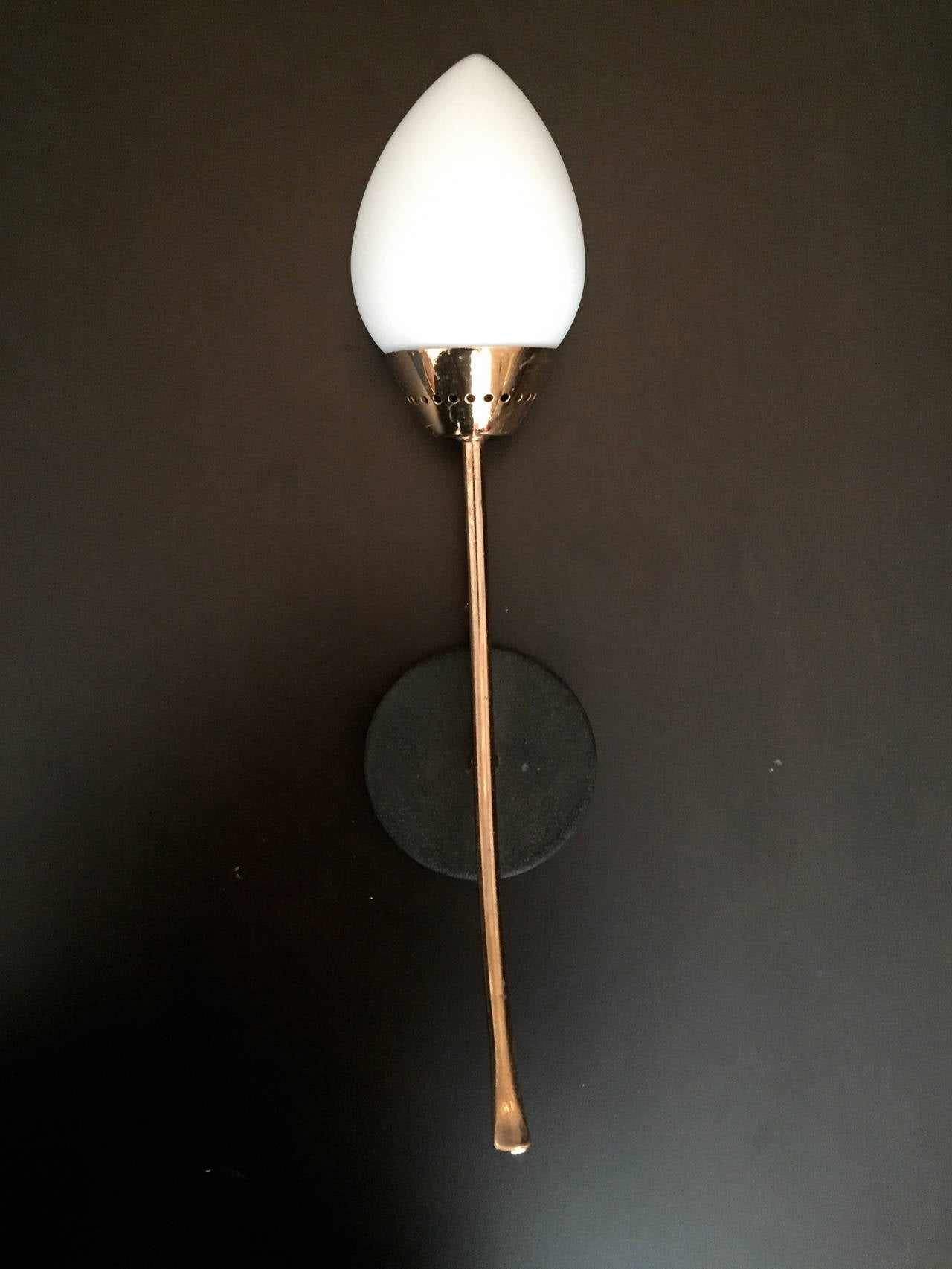 A wonderful pair of 1960s French Mid-Century wall lights composed of rose gold and black enamel fixtures holding a white egg glass globe. Rewired.