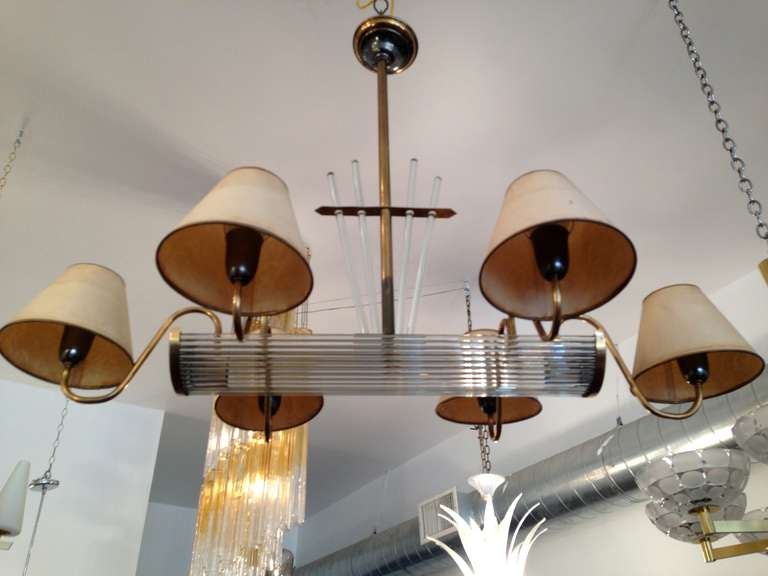 A wonderful French 1940 modernist chandelier with an aged brass and glass rod fixture and aged paper shades.