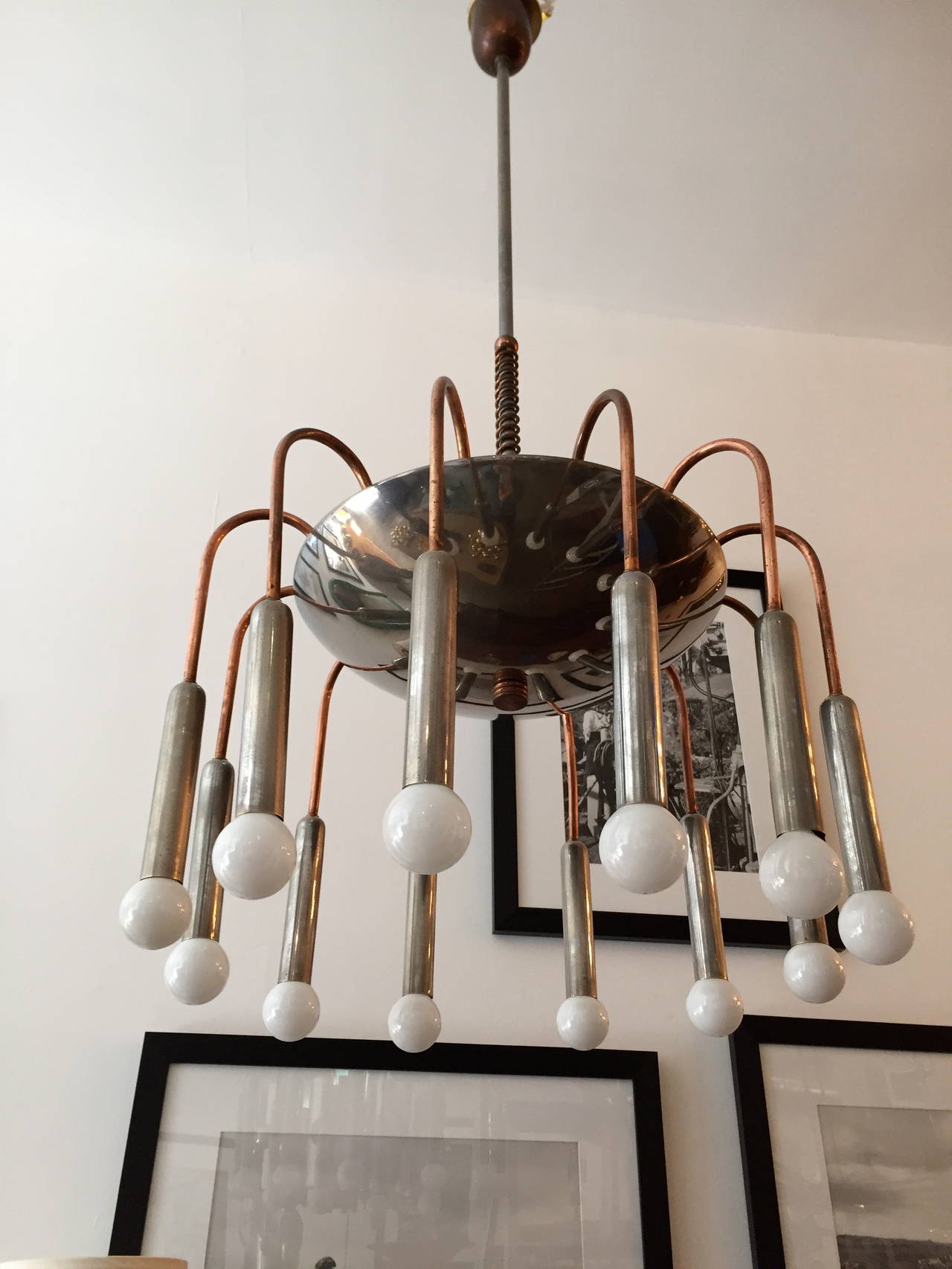 A great rare 1920s Italian Machine Age chandelier composed of an aged steel and copper fixture and decorative elements. 12 downward and three upward light sources. Great aged patina. Rewired.