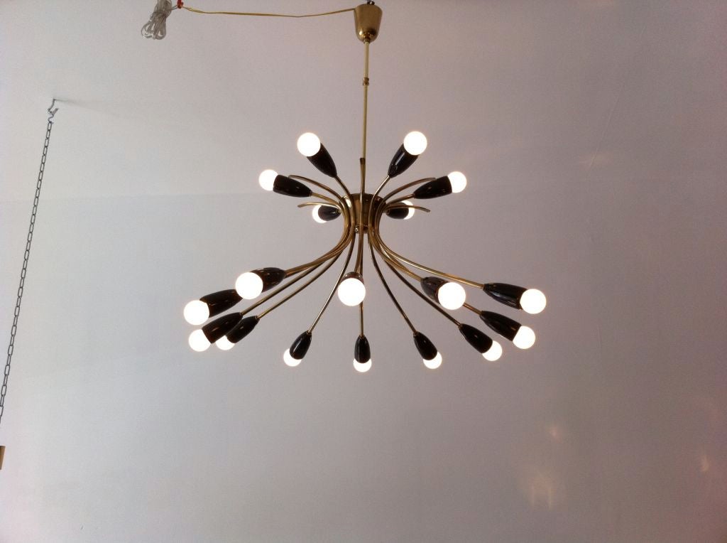 A playful 1950's 18 light  Italian brass chandelier with black enamel shades. The ceiling pole can be adjusted to your needs.